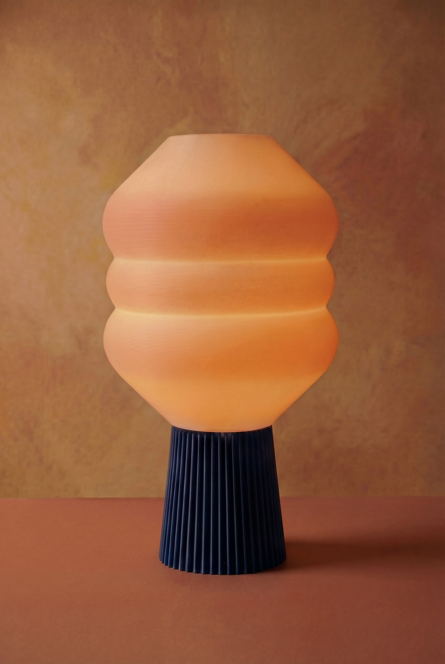 Big Koki NightBlue sur fond terracotta — lampe design biosourcée avec base bleue imprimée en 3D | Koki Design